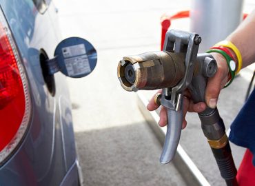 Human hand holding LPG pump nozzle on petrol station